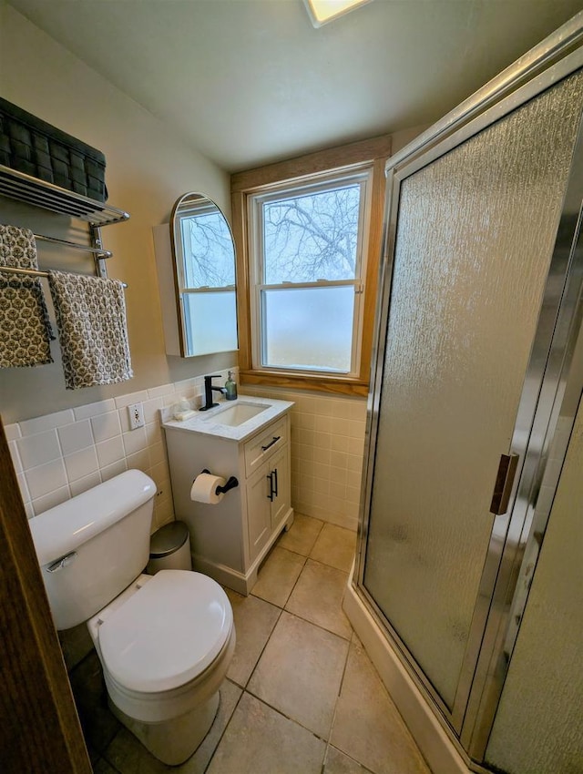 bathroom with tile walls, vanity, tile patterned floors, toilet, and walk in shower