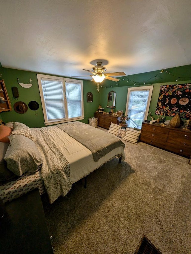 bedroom with ceiling fan, multiple windows, and carpet