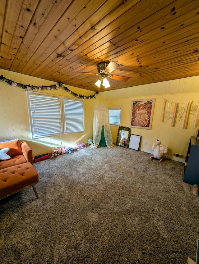 interior space with ceiling fan, carpet, and wood ceiling