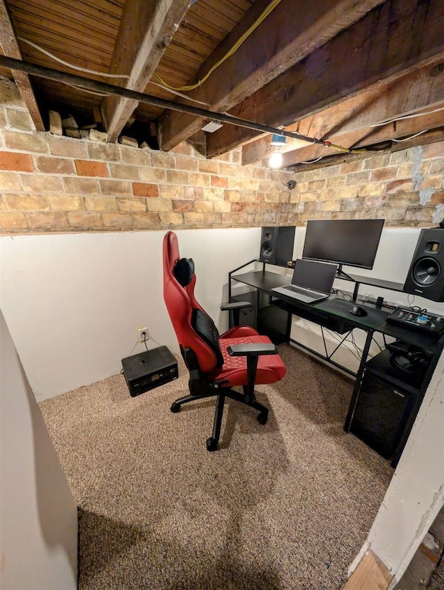 interior space with beam ceiling, brick wall, and carpet