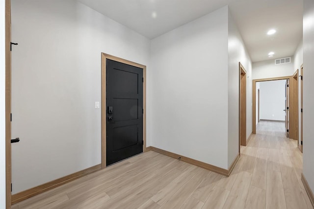 corridor featuring a barn door and light hardwood / wood-style flooring