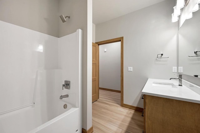 bathroom featuring hardwood / wood-style flooring, vanity, and bathing tub / shower combination