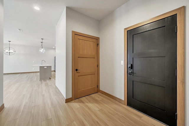 foyer with sink and light hardwood / wood-style flooring