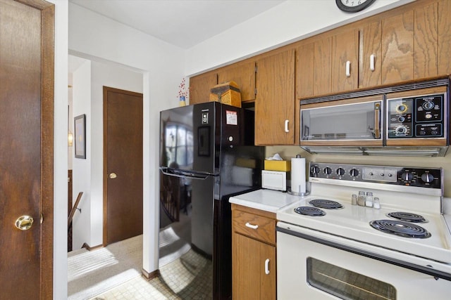 kitchen featuring white electric stove and black refrigerator