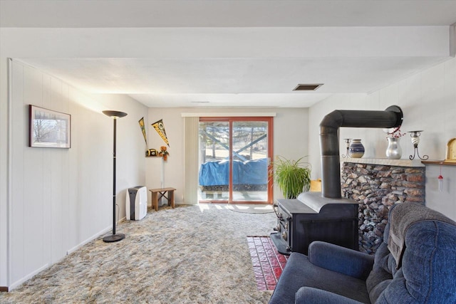 carpeted living room featuring a wood stove