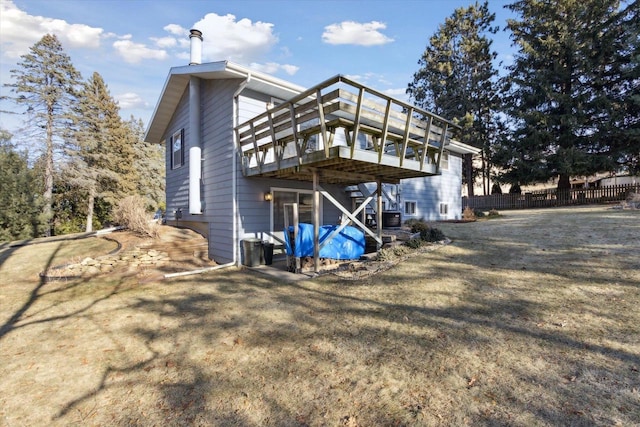 rear view of house with a wooden deck and a yard