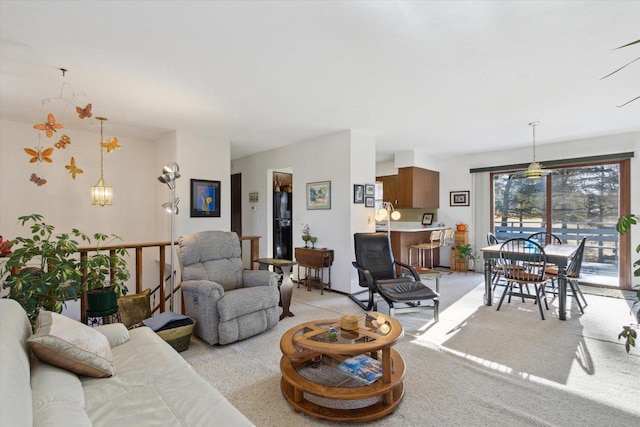 living room featuring light carpet and a notable chandelier