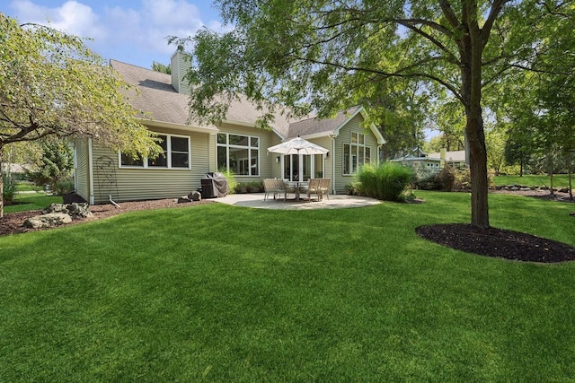 back of property featuring a patio area and a lawn