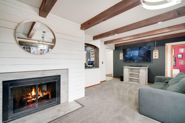 carpeted living room with beamed ceiling, a premium fireplace, and wooden walls