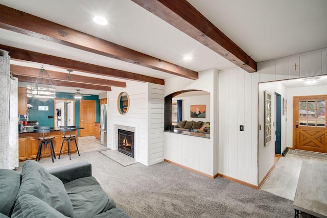 carpeted living room with beamed ceiling