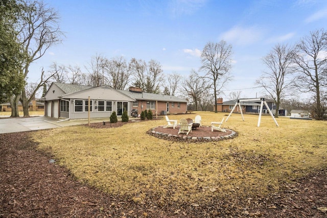 view of yard featuring a playground and a fire pit