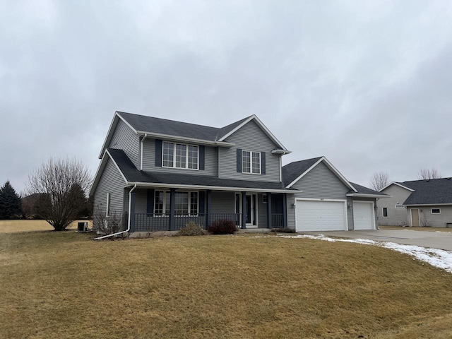 view of property featuring a garage, a front lawn, and covered porch