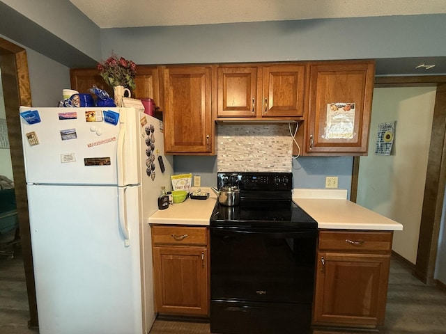 kitchen featuring white refrigerator, black range with electric cooktop, and tasteful backsplash