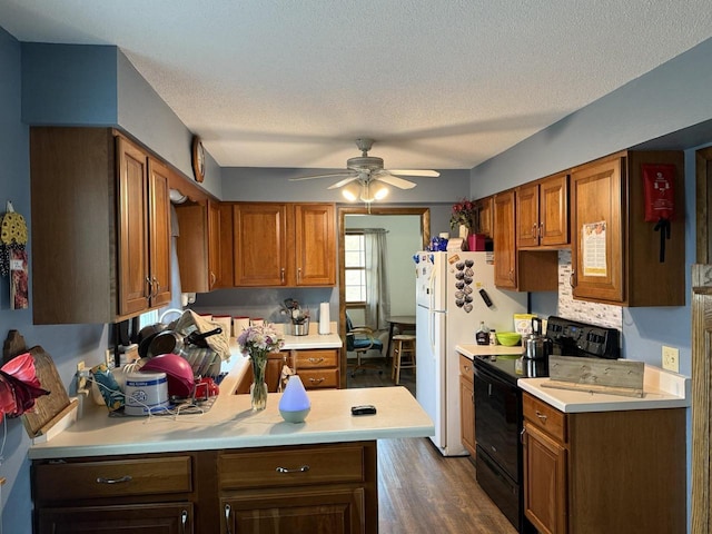 kitchen with black electric range oven, a textured ceiling, dark hardwood / wood-style floors, kitchen peninsula, and ceiling fan