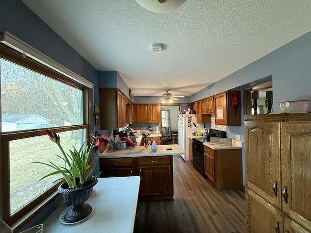 kitchen featuring dark wood-type flooring, a textured ceiling, electric range, white refrigerator, and ceiling fan