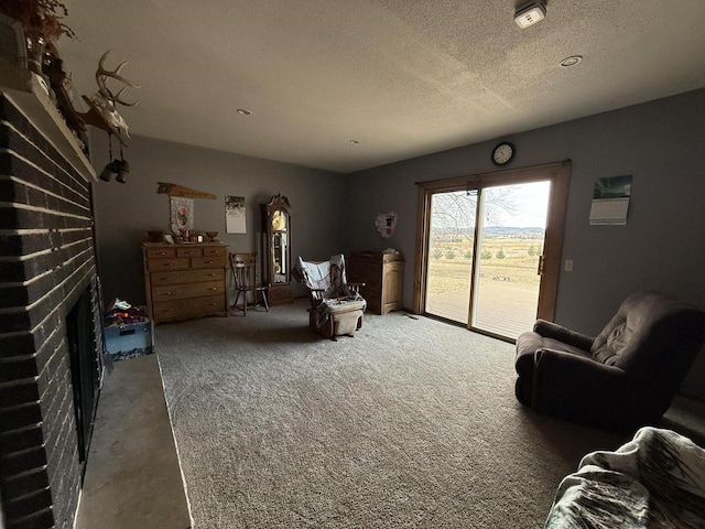 living area with a fireplace, a textured ceiling, and carpet