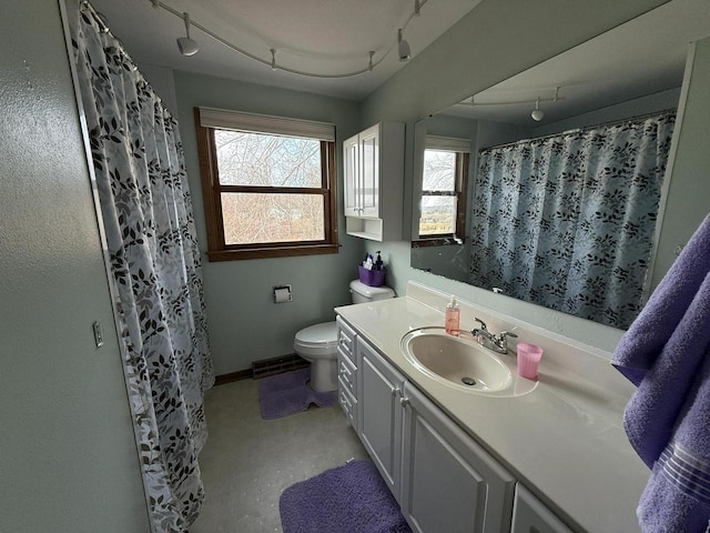 bathroom featuring vanity, toilet, track lighting, and a shower with shower curtain