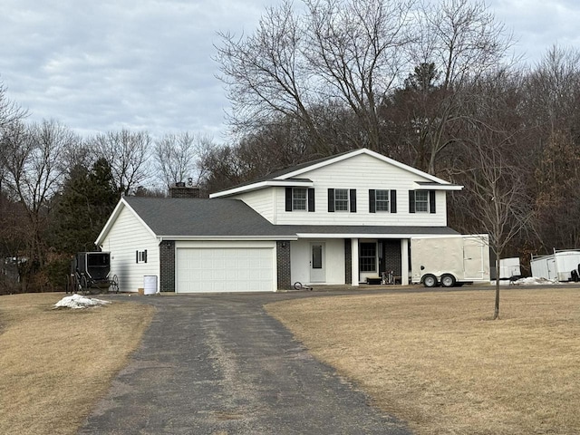 front facade with a garage, a porch, and a front yard