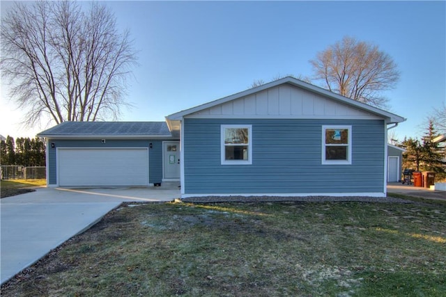 ranch-style house featuring a garage and a yard