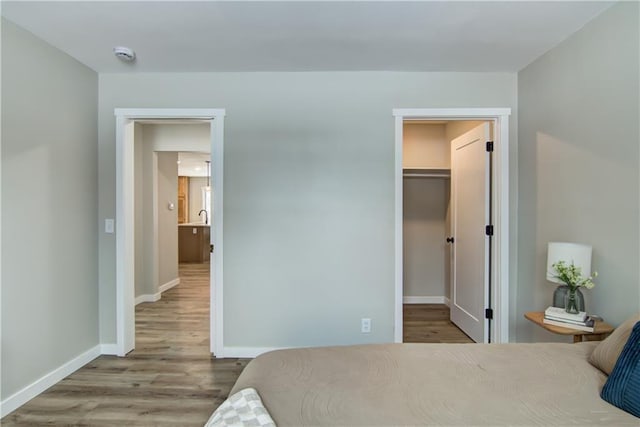 bedroom featuring a walk in closet and light wood-type flooring