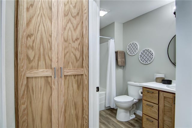 full bathroom with vanity, hardwood / wood-style floors, shower / bath combo, and toilet