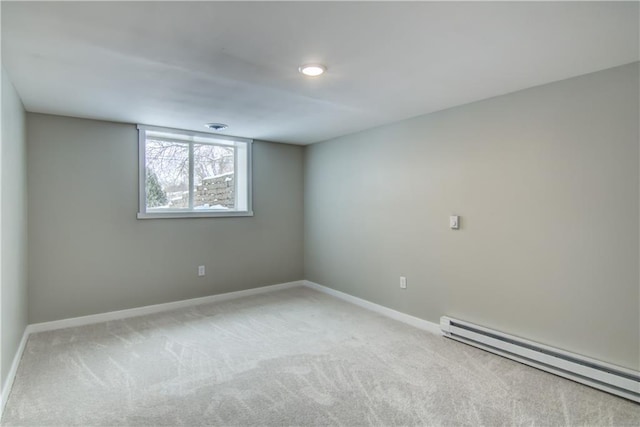 spare room featuring a baseboard radiator and light carpet