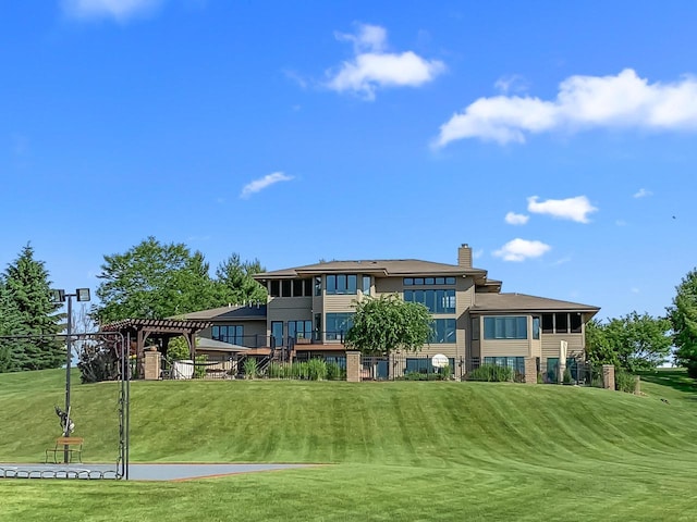 back of property with a yard and a pergola