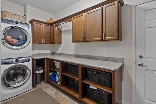 clothes washing area with cabinets and stacked washing maching and dryer