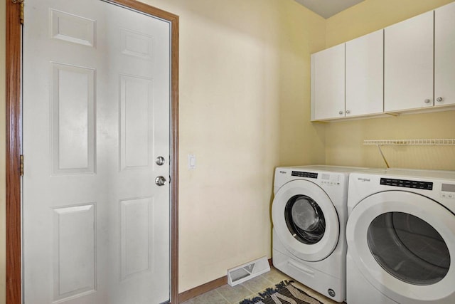 laundry area featuring cabinets, light tile patterned flooring, and washing machine and clothes dryer