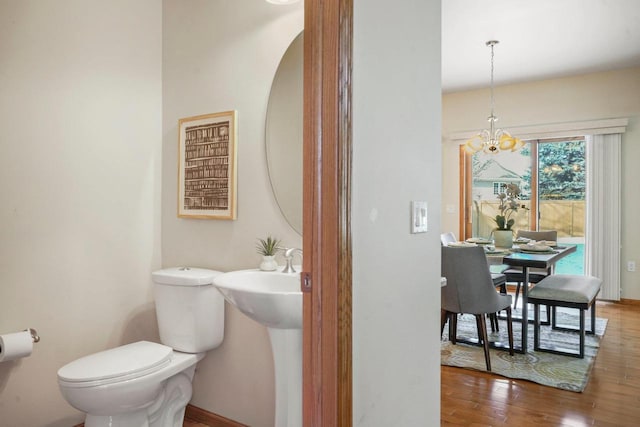 bathroom featuring toilet, hardwood / wood-style floors, and a notable chandelier