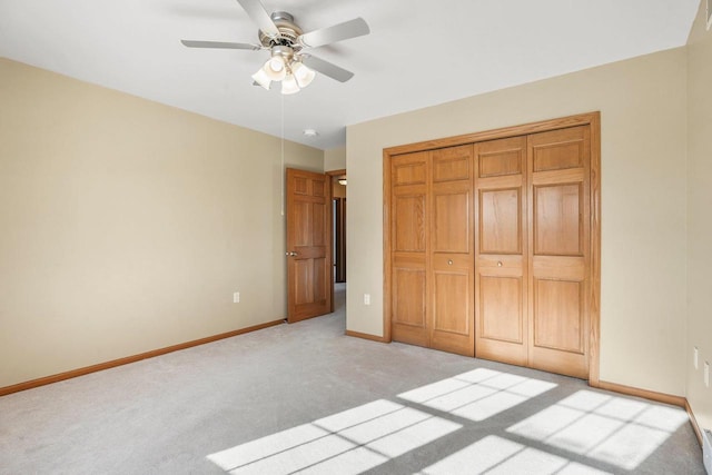 unfurnished bedroom featuring light carpet, ceiling fan, and a closet