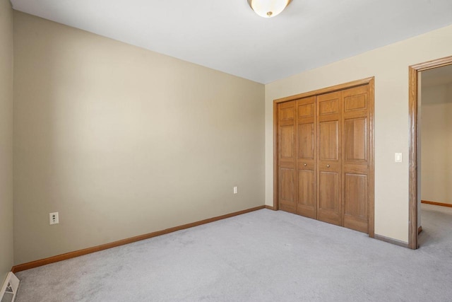 unfurnished bedroom featuring a closet and light carpet