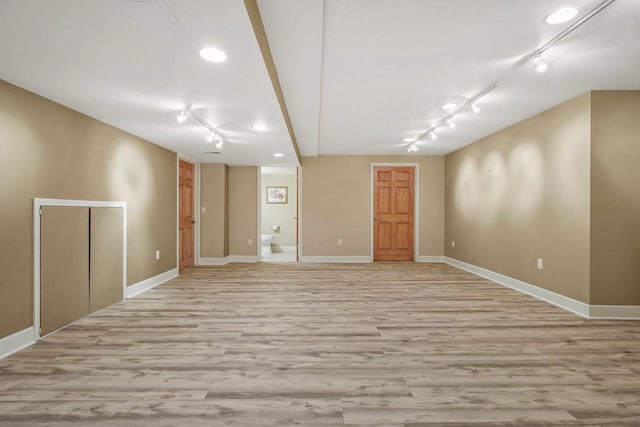 spare room with light hardwood / wood-style flooring and rail lighting