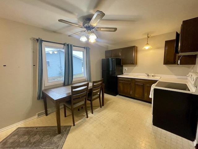 kitchen featuring black refrigerator, pendant lighting, sink, stove, and ceiling fan