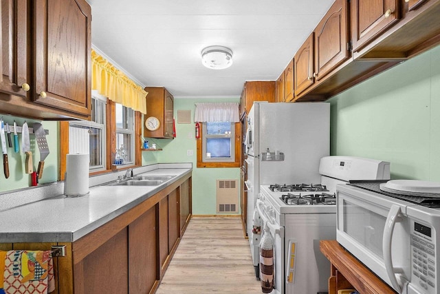 kitchen featuring sink, white appliances, and light hardwood / wood-style floors