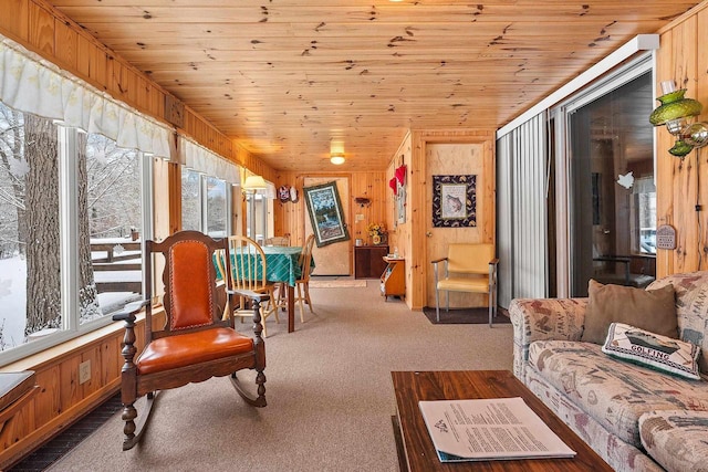 living room featuring light carpet, wood ceiling, and wood walls