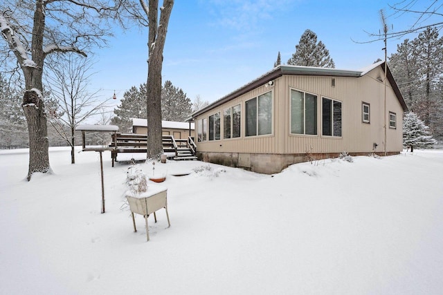 view of snowy exterior featuring a deck