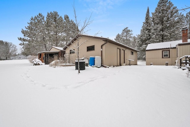 view of snow covered back of property