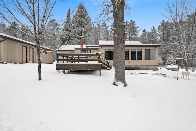 snow covered rear of property featuring a wooden deck