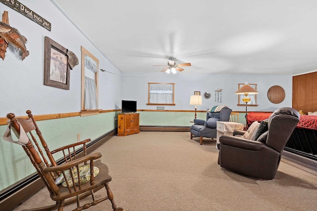 living room with a baseboard heating unit, ceiling fan, and carpet flooring