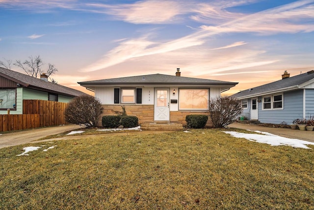 ranch-style home featuring a lawn