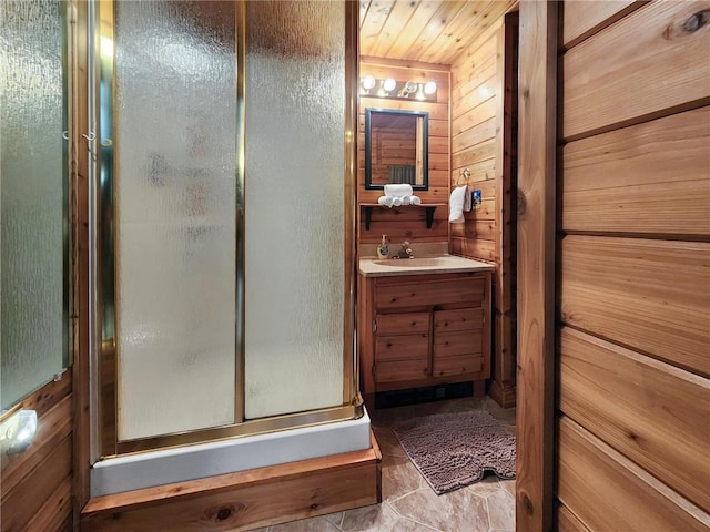 bathroom featuring walk in shower, vanity, and wooden walls