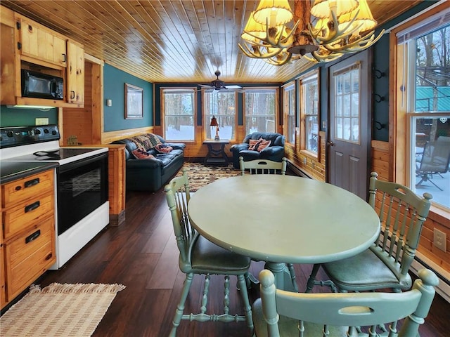 dining space with dark hardwood / wood-style flooring, wood ceiling, and a wealth of natural light