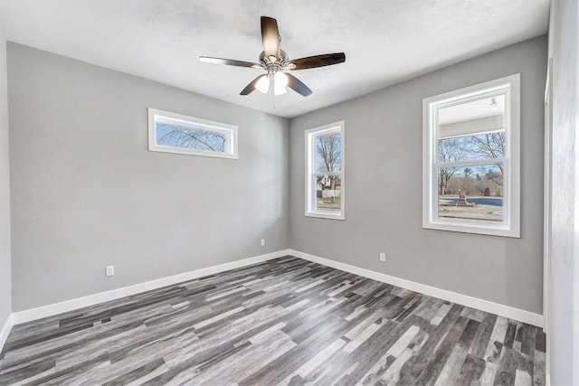 spare room featuring ceiling fan, a healthy amount of sunlight, and dark hardwood / wood-style floors