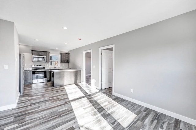 kitchen with hardwood / wood-style flooring, stainless steel appliances, and dark brown cabinets