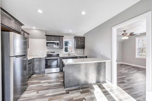 kitchen featuring stainless steel appliances, hardwood / wood-style flooring, sink, and dark brown cabinetry