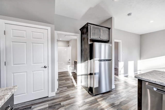 kitchen with dark brown cabinetry, hardwood / wood-style flooring, and appliances with stainless steel finishes