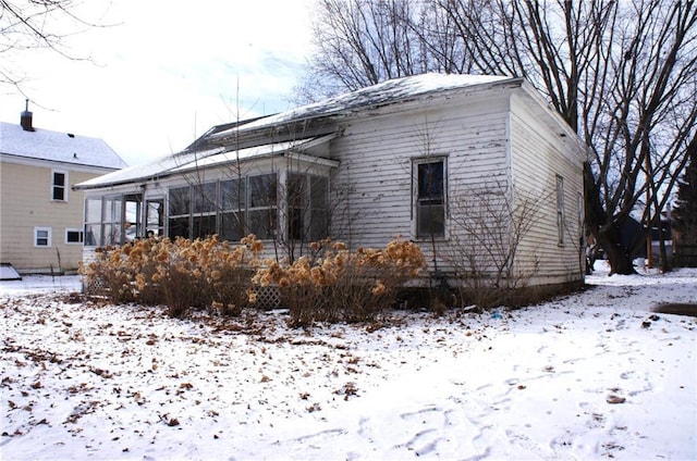 snow covered property with a sunroom