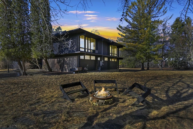 back house at dusk with a fire pit