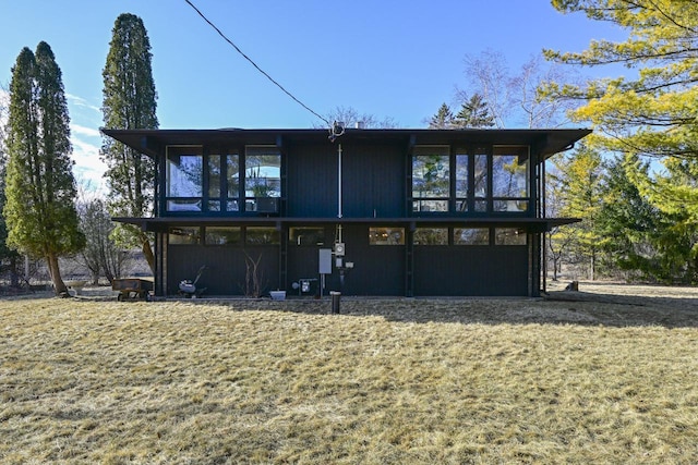 back of house with a lawn and a sunroom